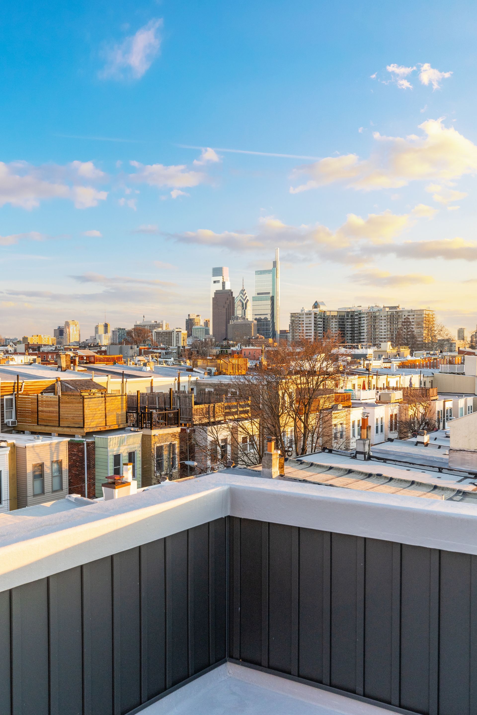 A view of a city from a balcony with snow on the ground.