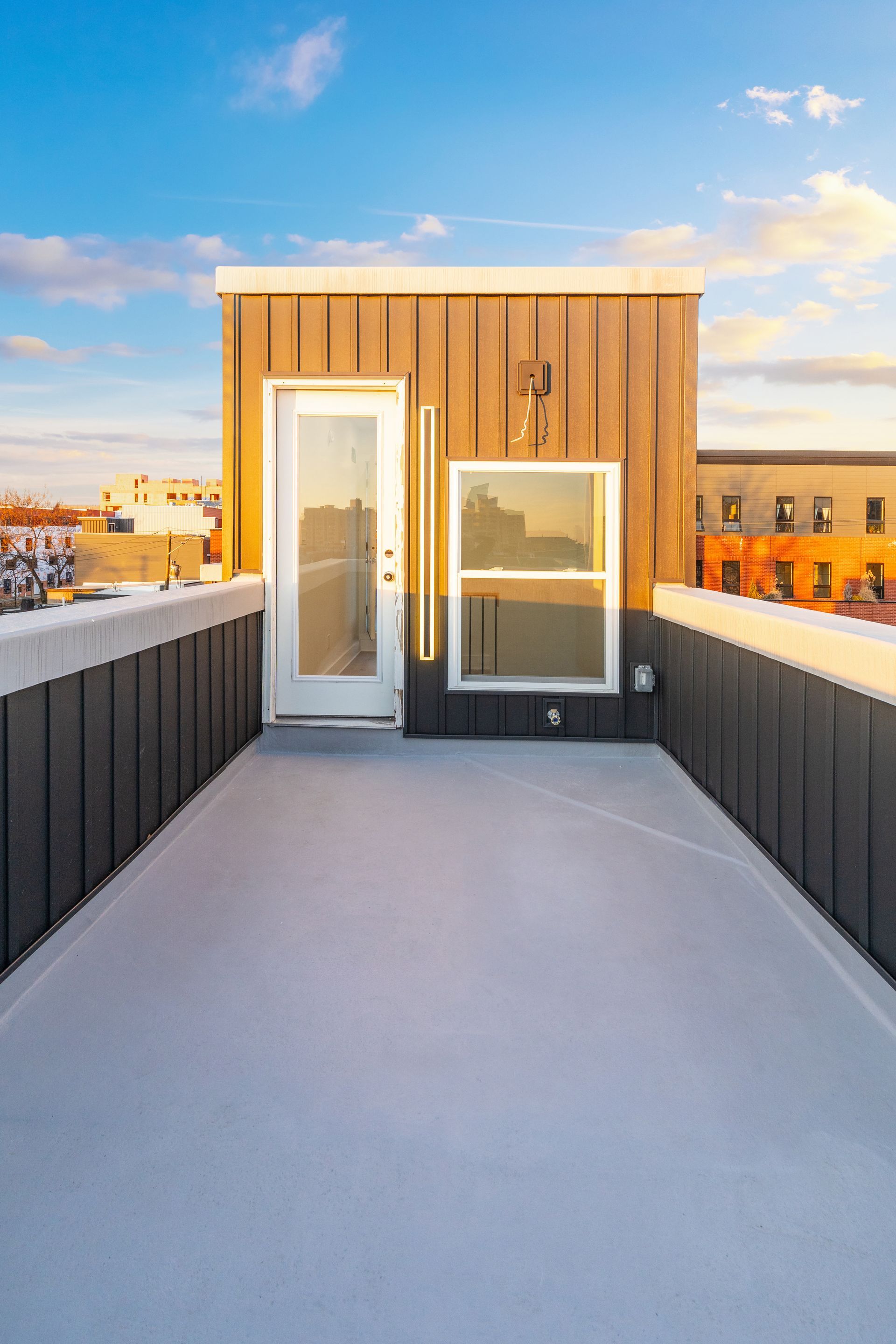 There is a rooftop deck with a door and a window.