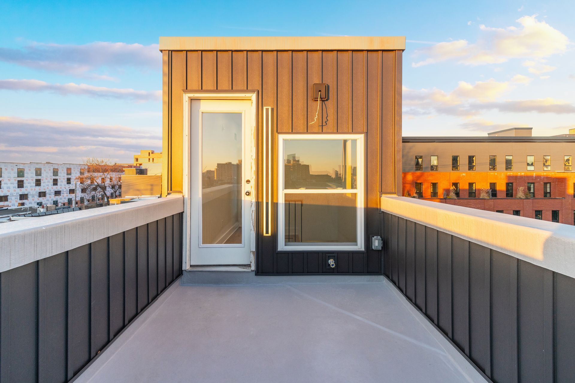 There is a rooftop deck with a door and a window.