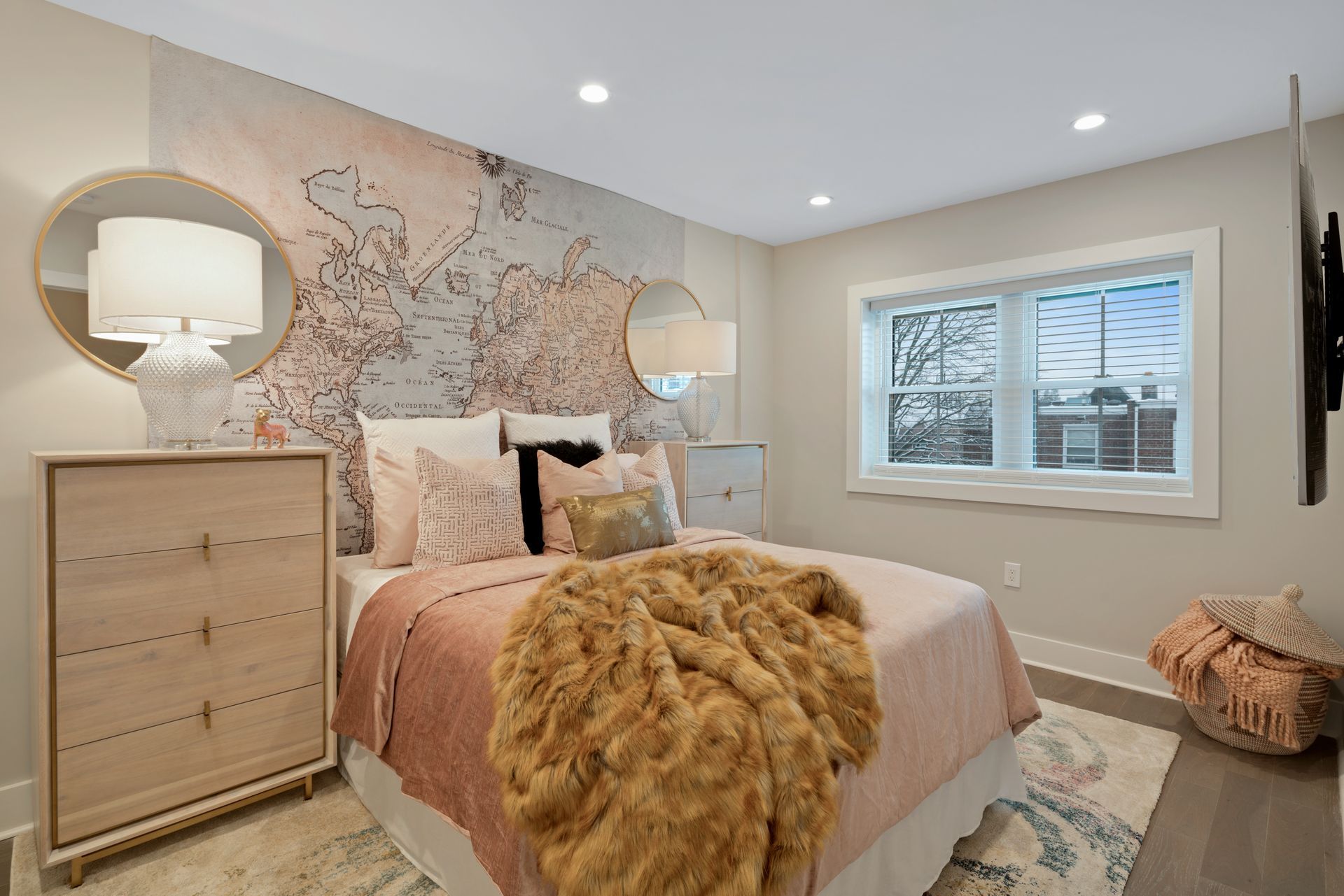 A bedroom with a bed , dresser , mirror and television.