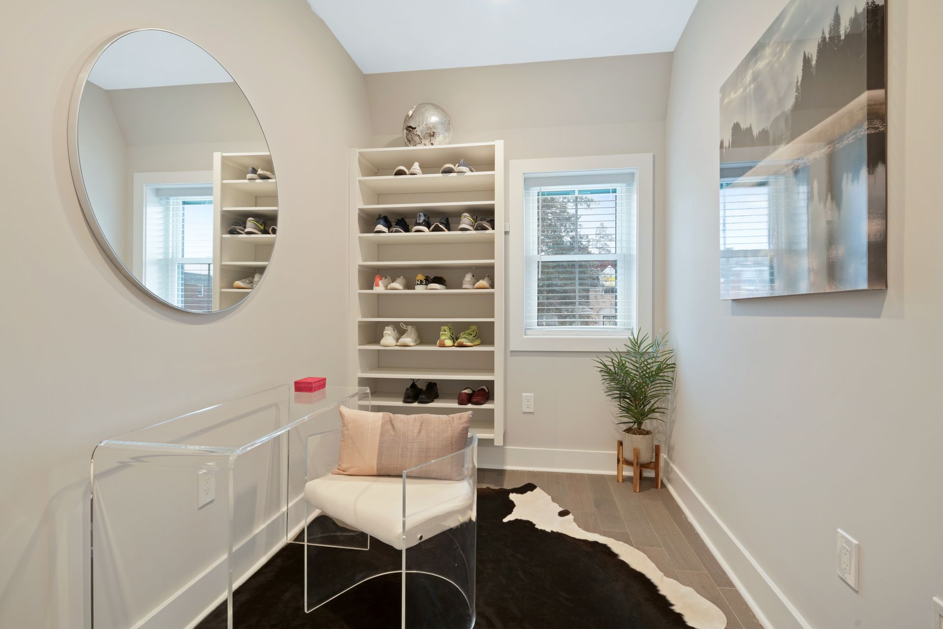 A small room with a chair and a round mirror