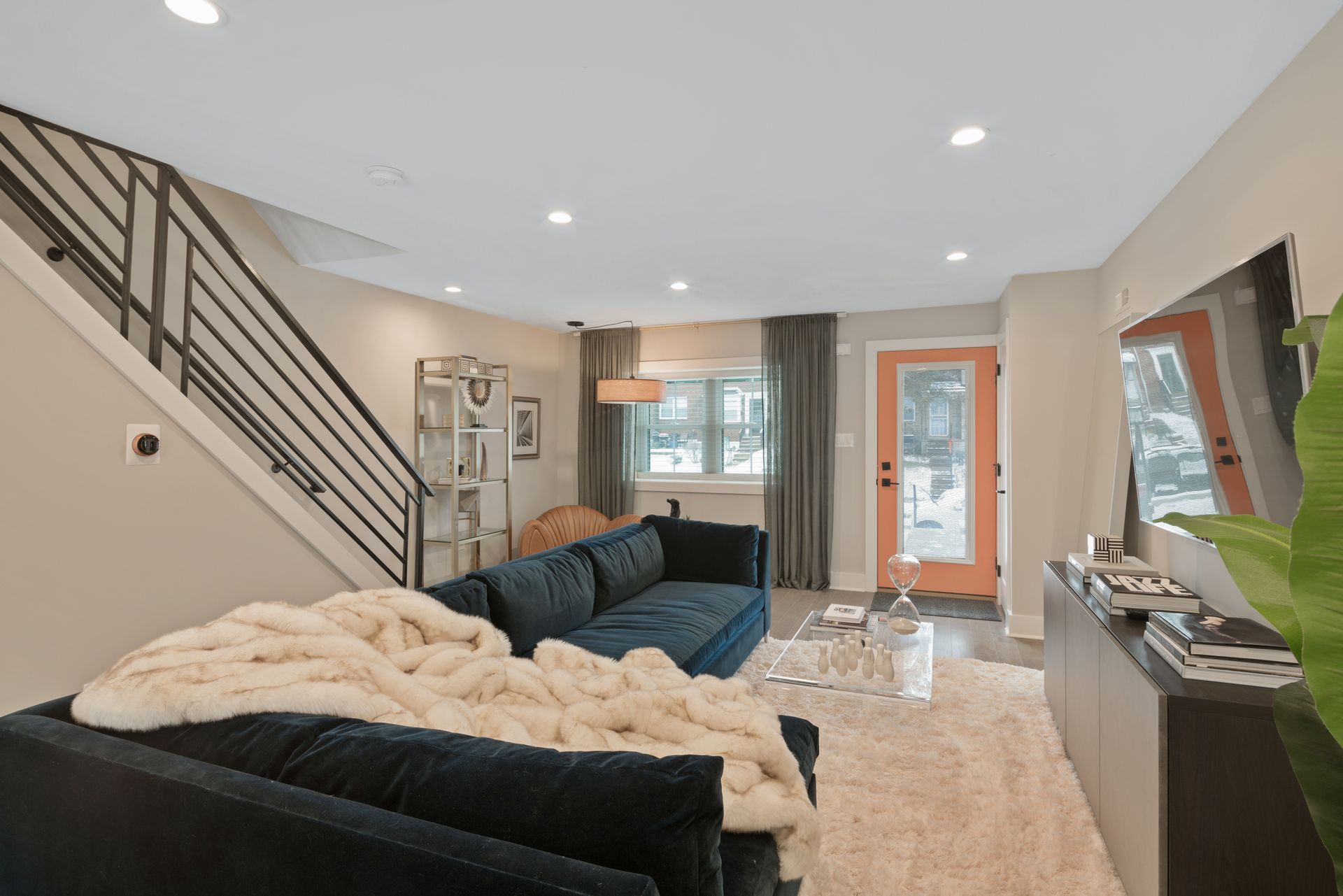 A living room with a couch , television , and stairs.