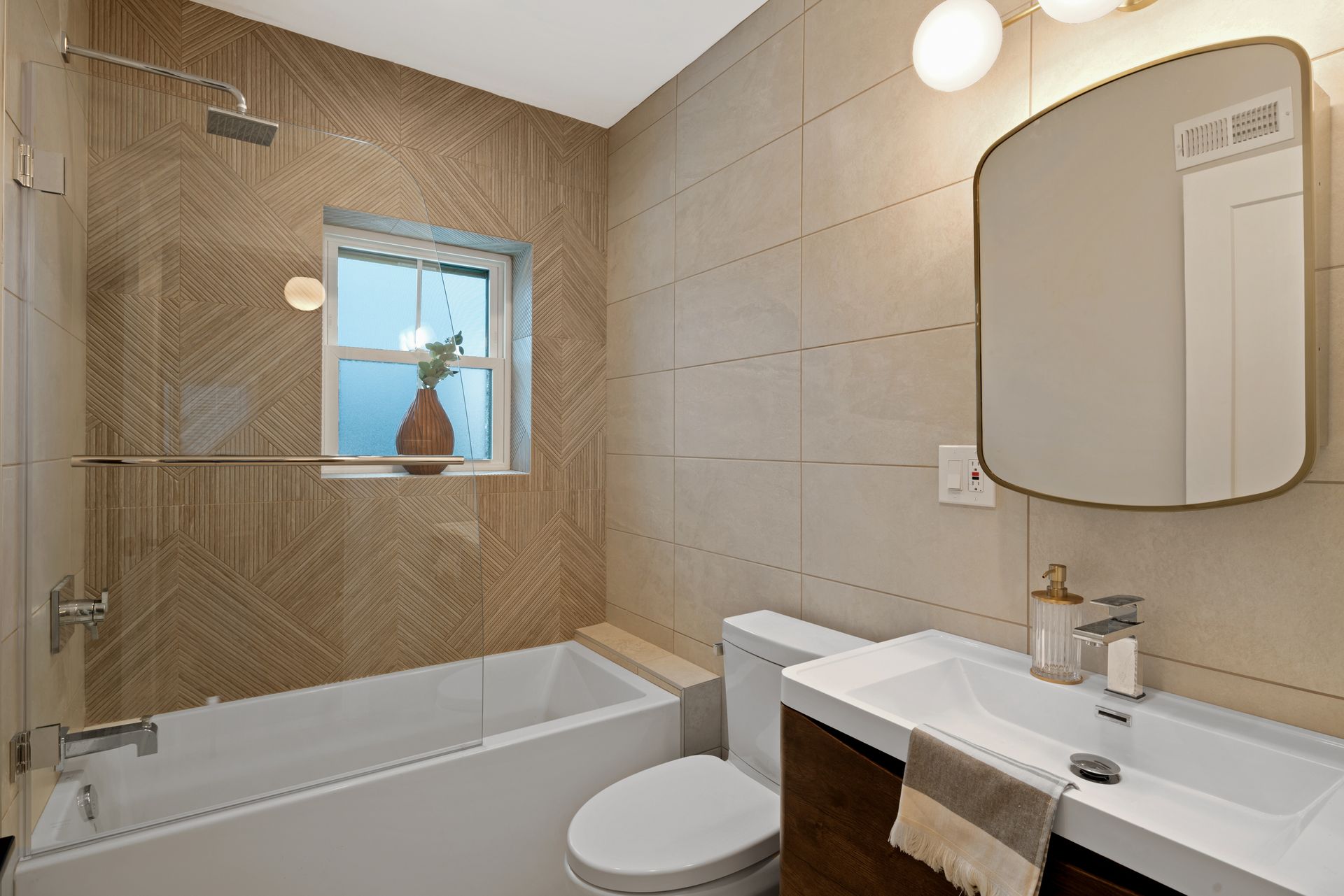 A bathroom with a tub , toilet , sink and mirror.