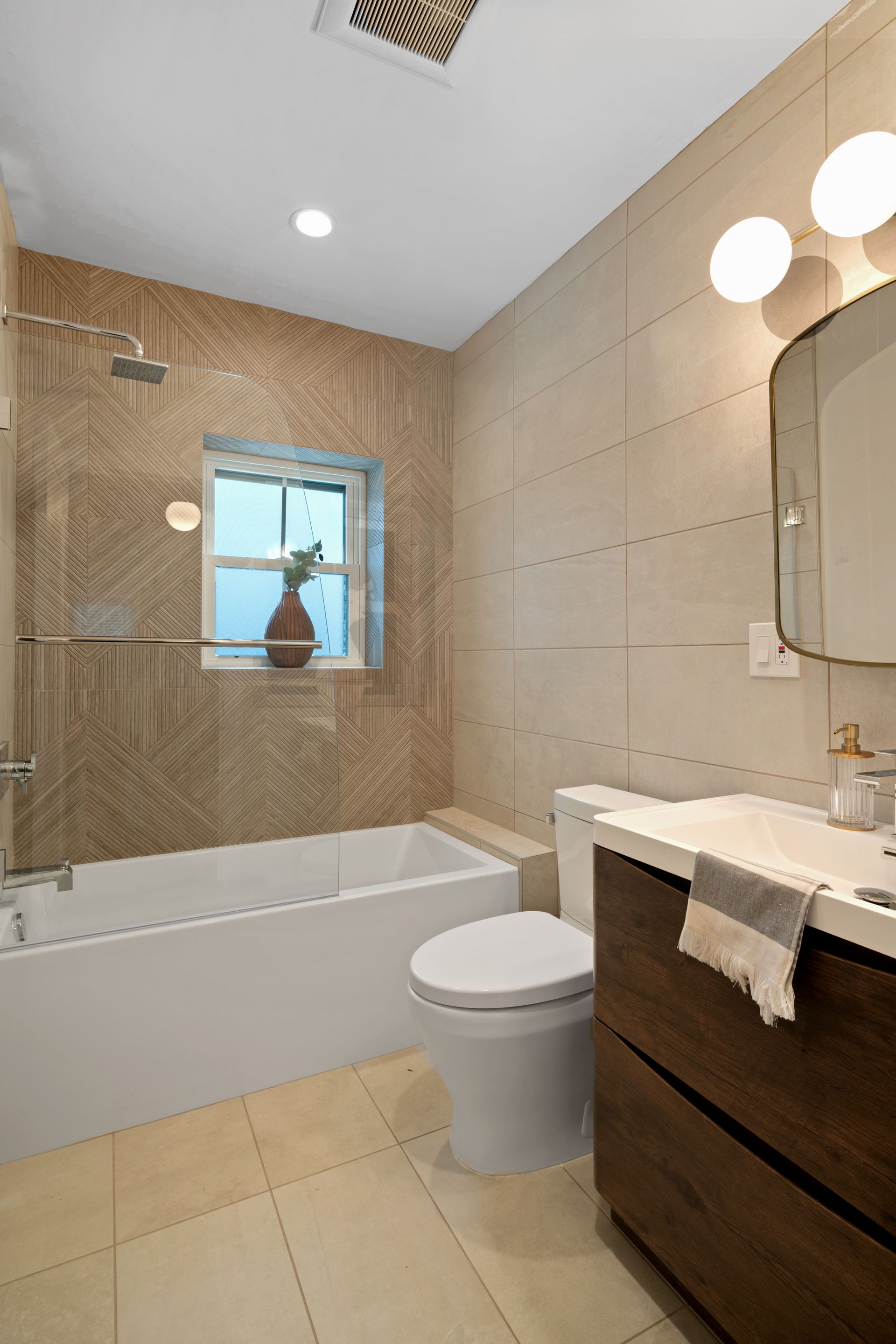 A bathroom with a toilet , sink , tub and shower.