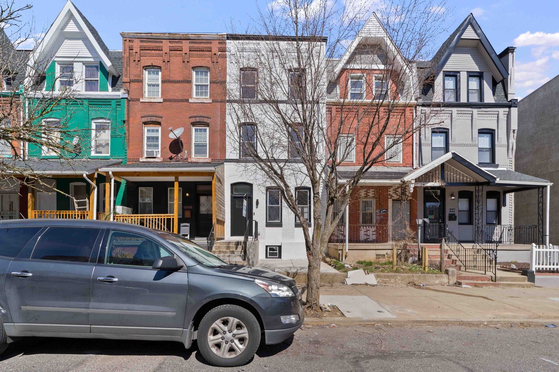 A car is parked in front of a row of houses