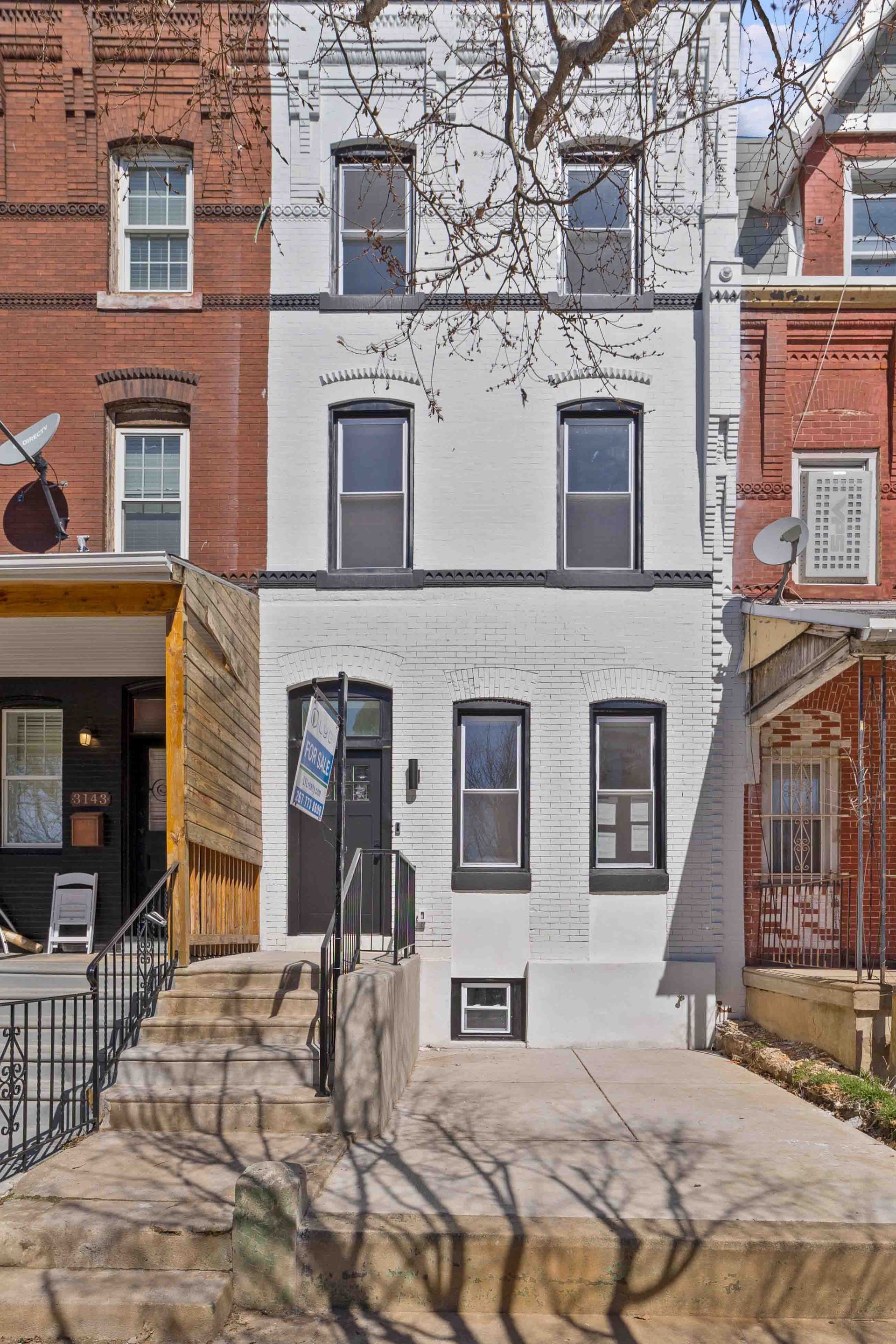 A row of brick buildings with a white building in the middle.