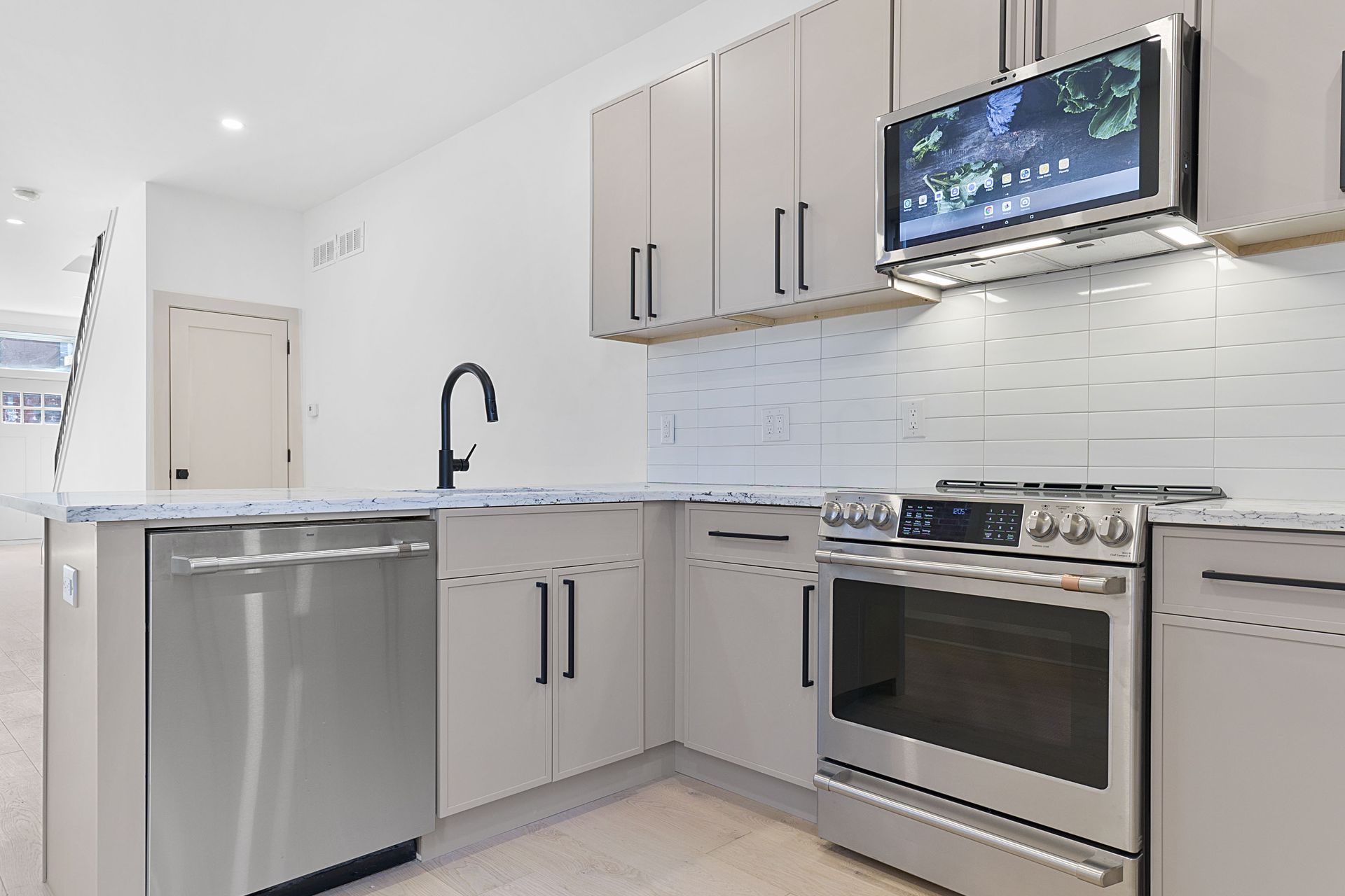 A kitchen with stainless steel appliances and white cabinets
