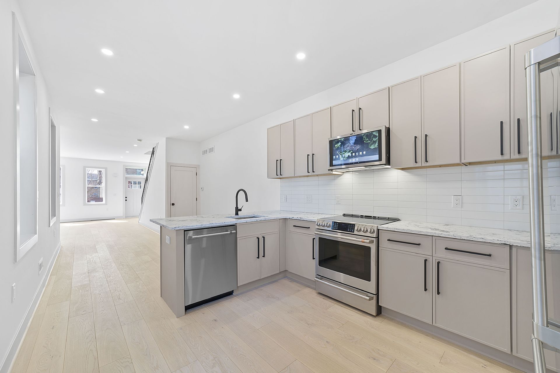 A kitchen with stainless steel appliances and white cabinets