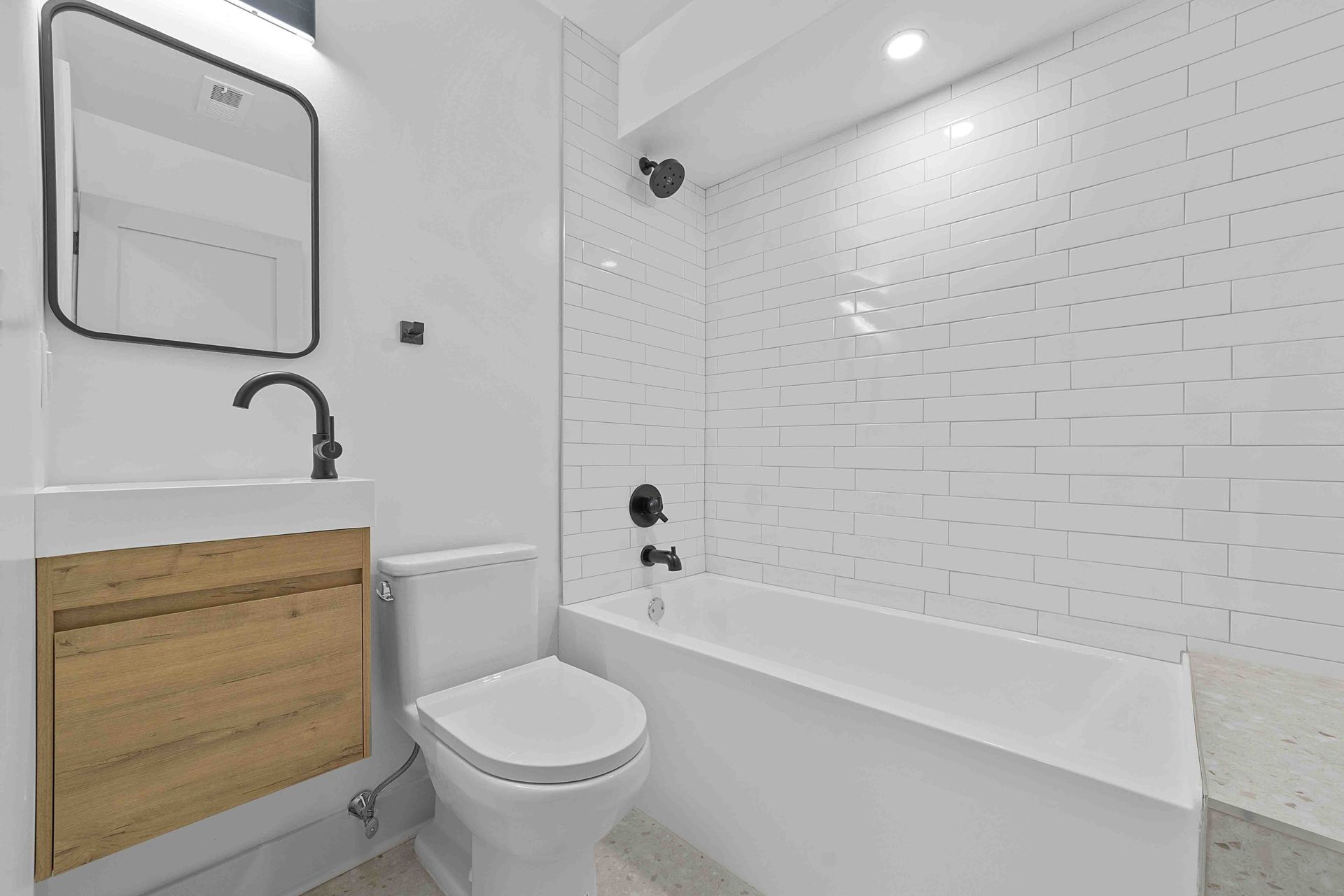 A bathroom with a toilet , sink and bathtub.
