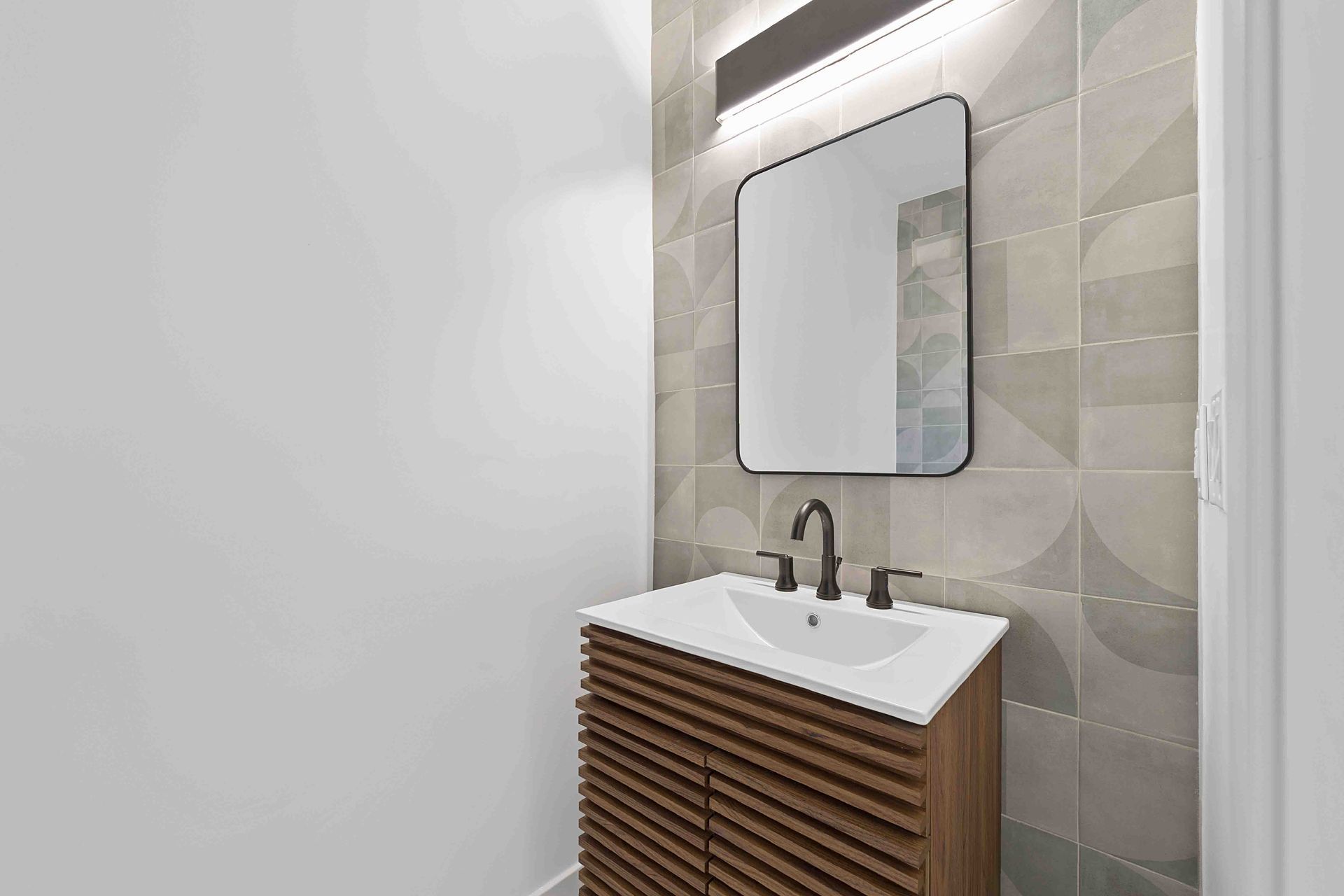 A bathroom with a sink and a mirror on the wall.