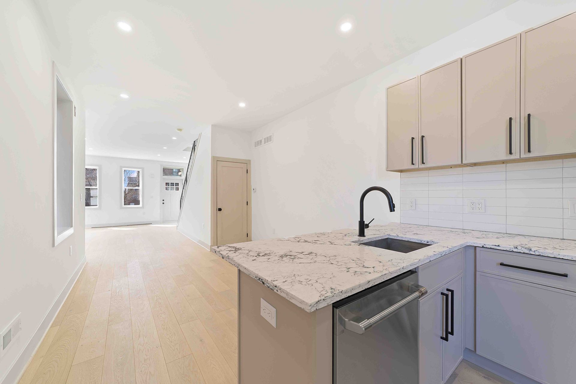 An empty kitchen with stainless steel appliances and granite counter tops.