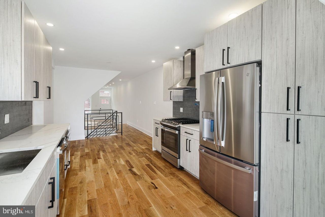 A kitchen with stainless steel appliances and hardwood floors.