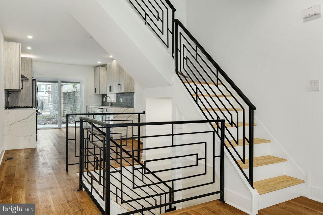 A picture of a staircase in a house with a wrought iron railing.