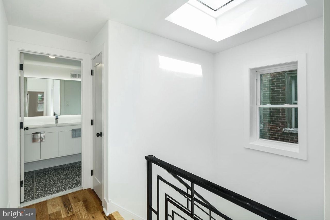 A staircase in a house with a skylight and a window.