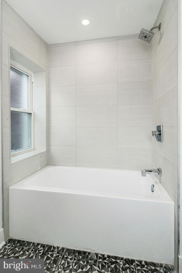 A bathroom with a bathtub and a shower.