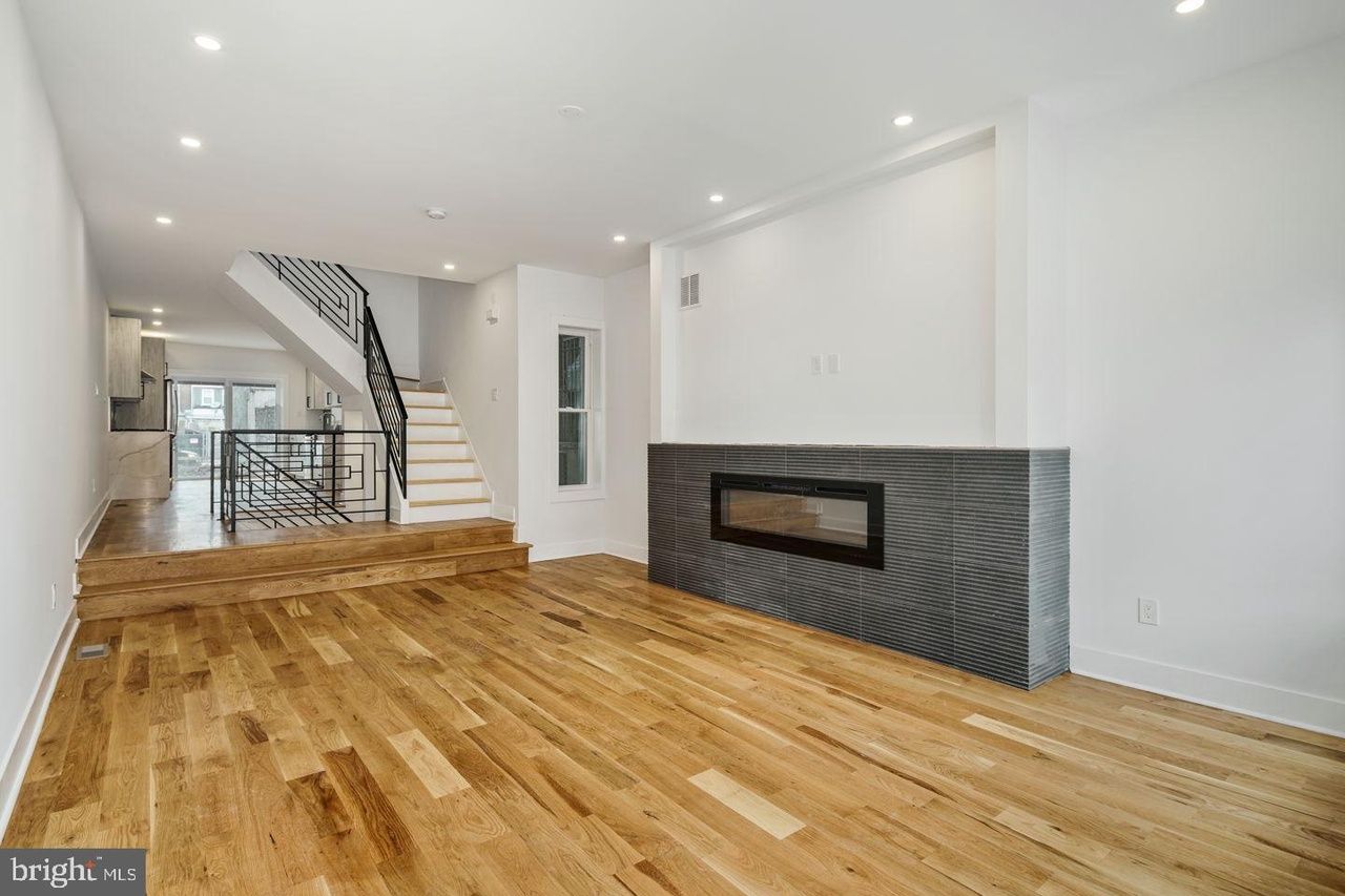 A living room with hardwood floors and a fireplace.
