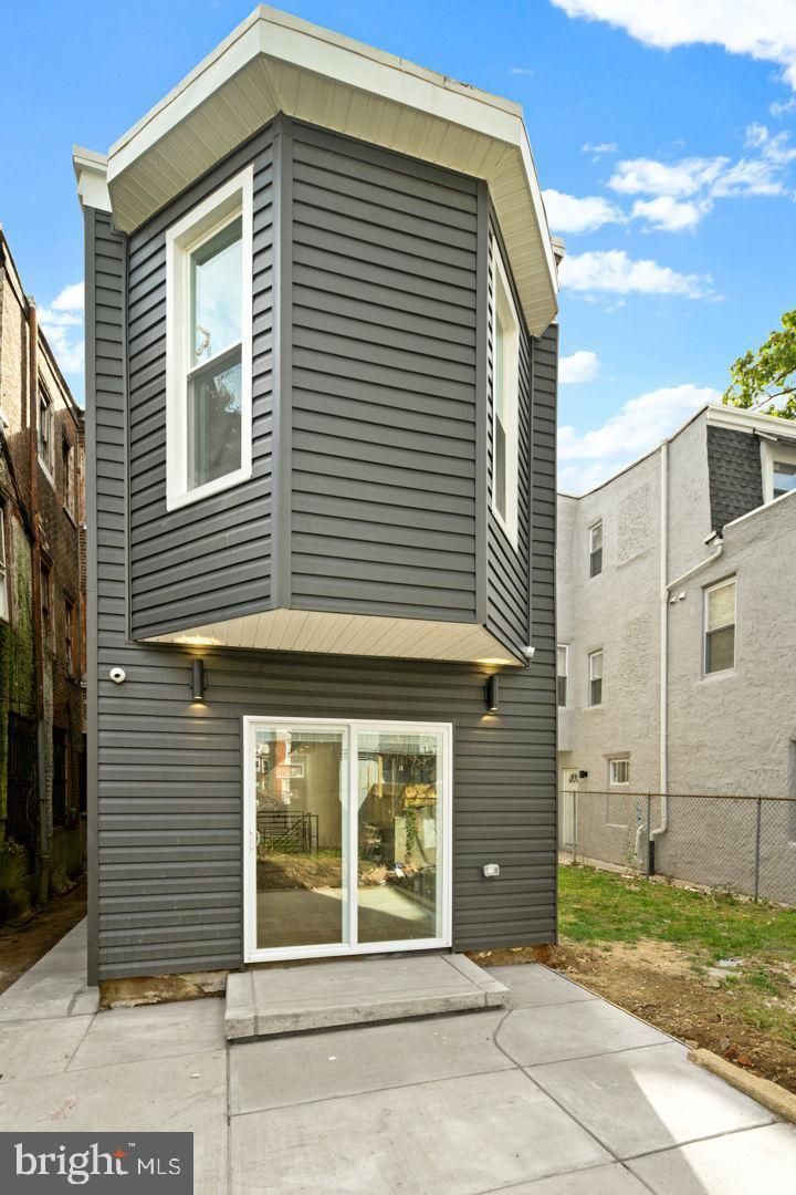 A very narrow house with a lot of windows and a patio.