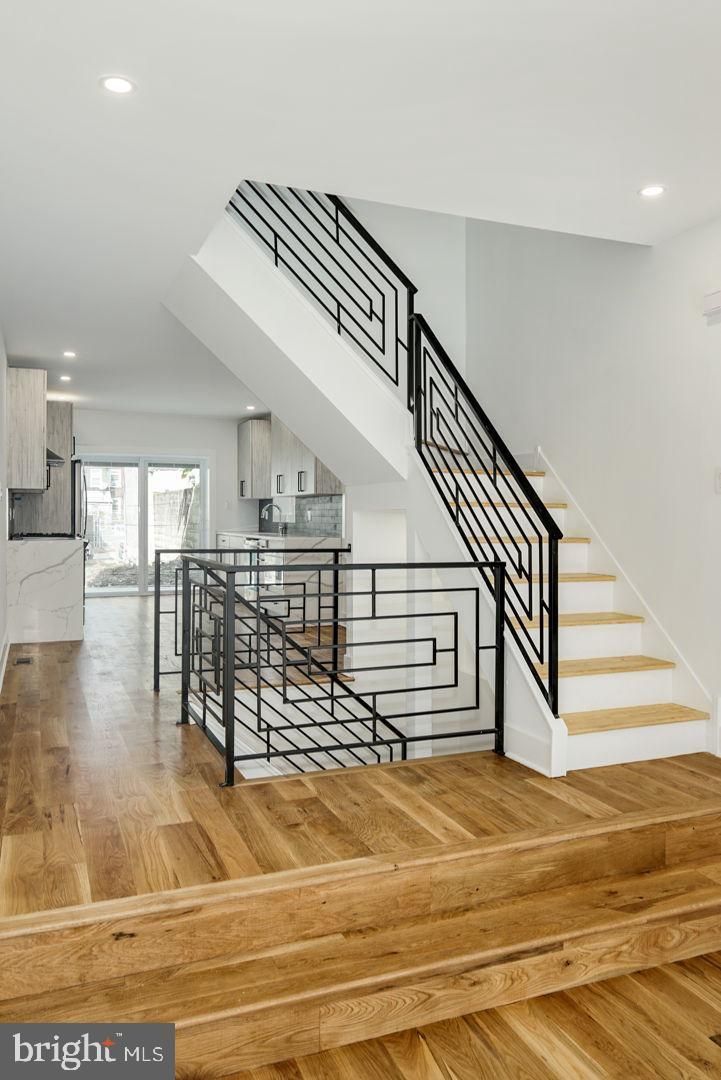 A staircase in a house with wooden floors and a metal railing.