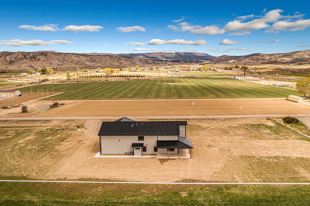 An aerial view of a house in the middle of a field.