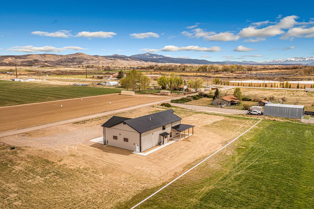 An aerial view of a house in the middle of a field.