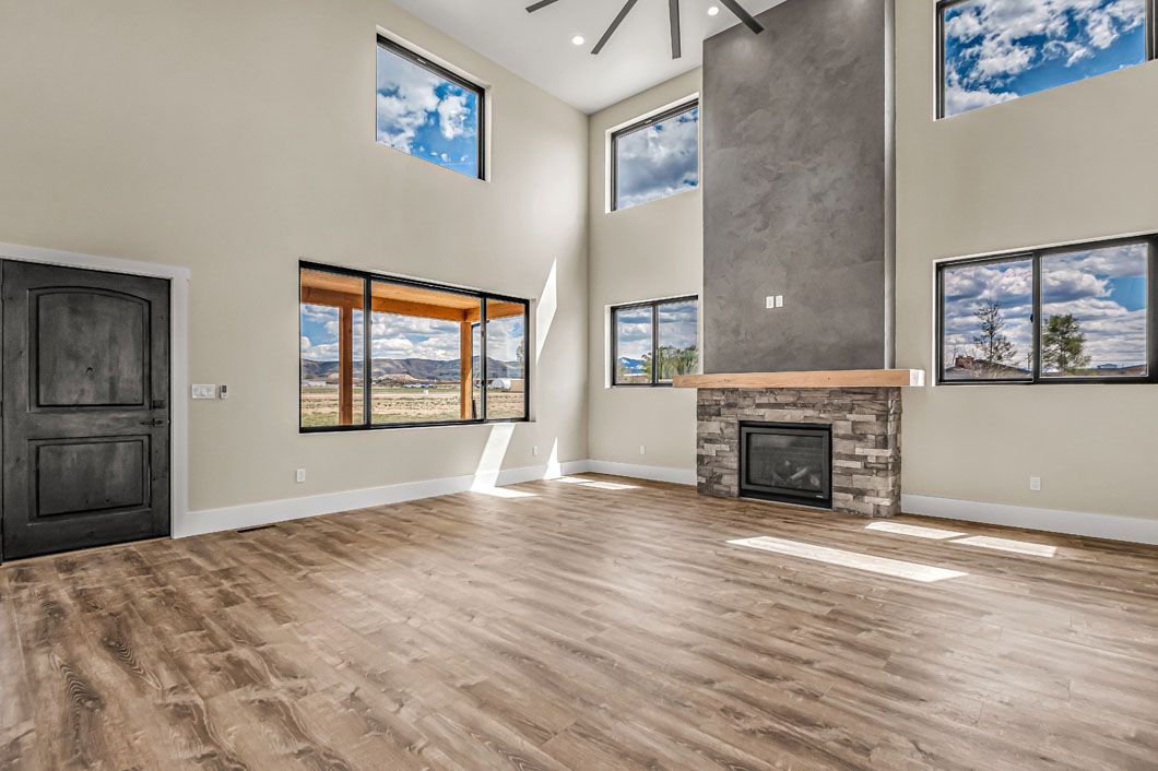 An empty living room with hardwood floors and a fireplace.