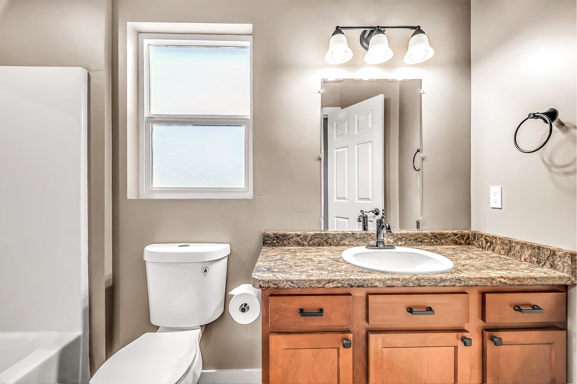 A bathroom with a toilet , sink , and mirror.