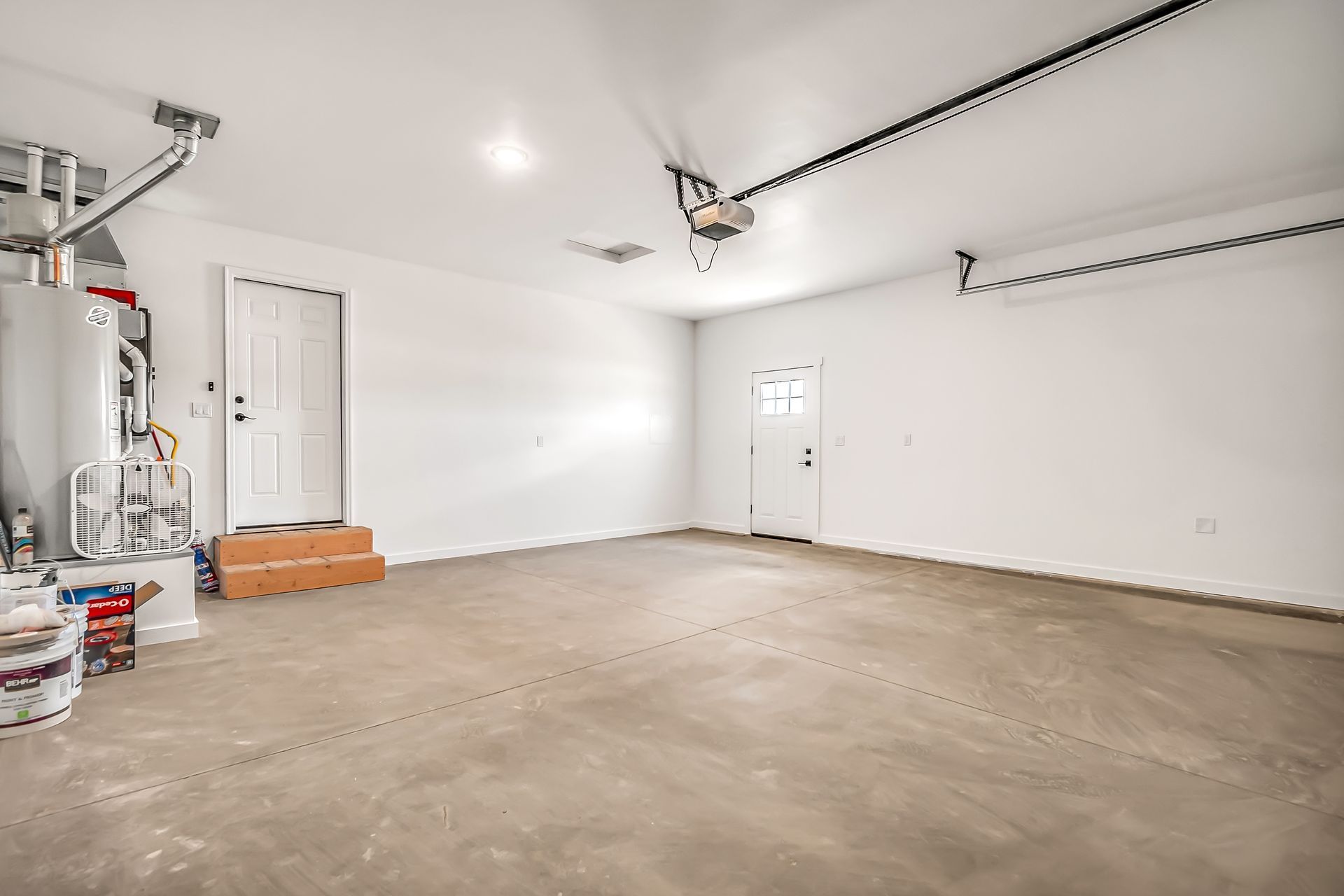 An empty garage with a concrete floor and white walls.
