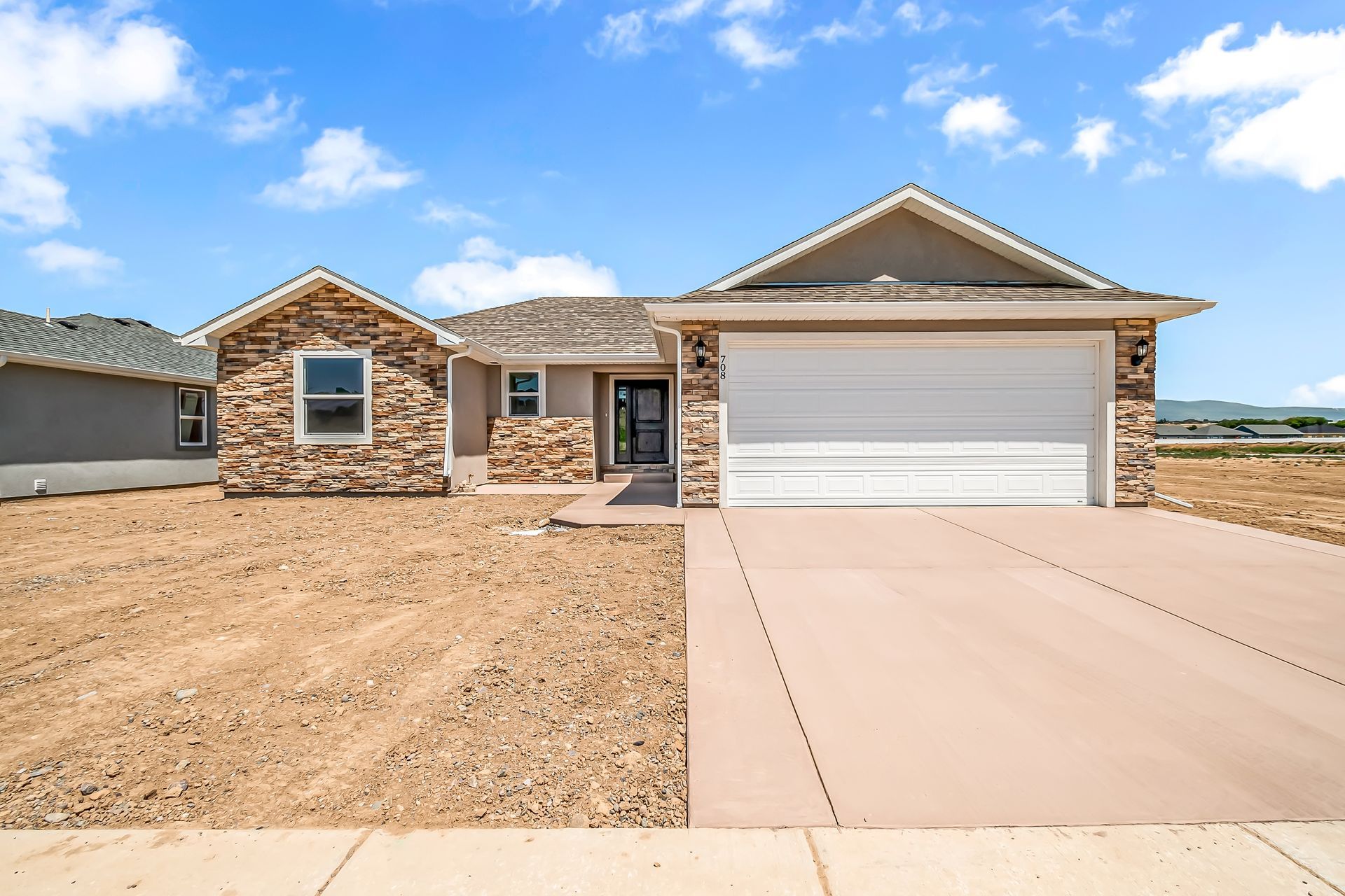 A house with a white garage door and a stone facade