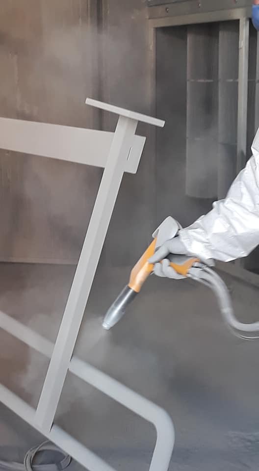 Imbianchino che spruzza vernice a polvere