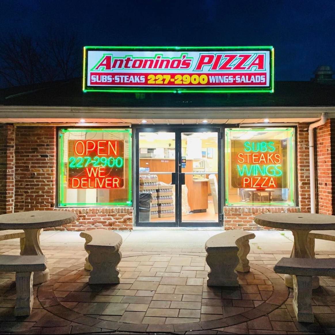 Antonino's Pizza storefront at night, lit signs: 