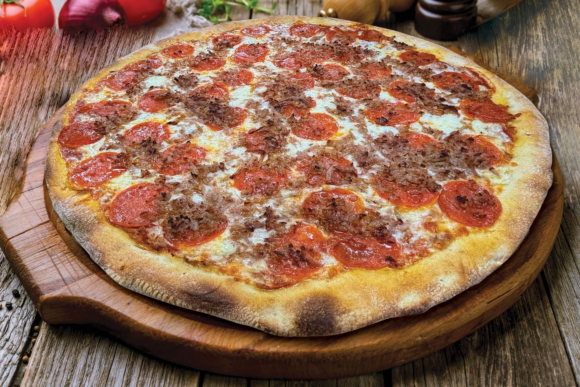 Pepperoni and sausage pizza on a wooden board.
