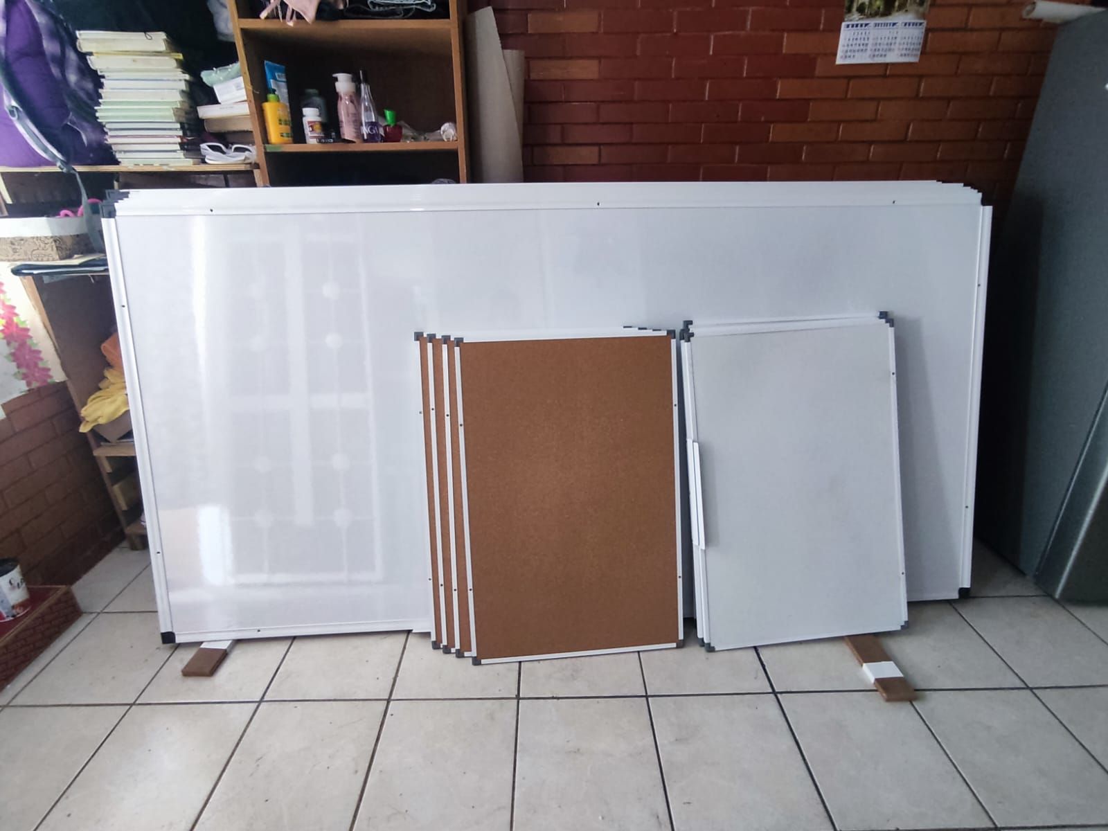 Un montón de pizarras blancas están colocadas sobre un suelo de baldosas.