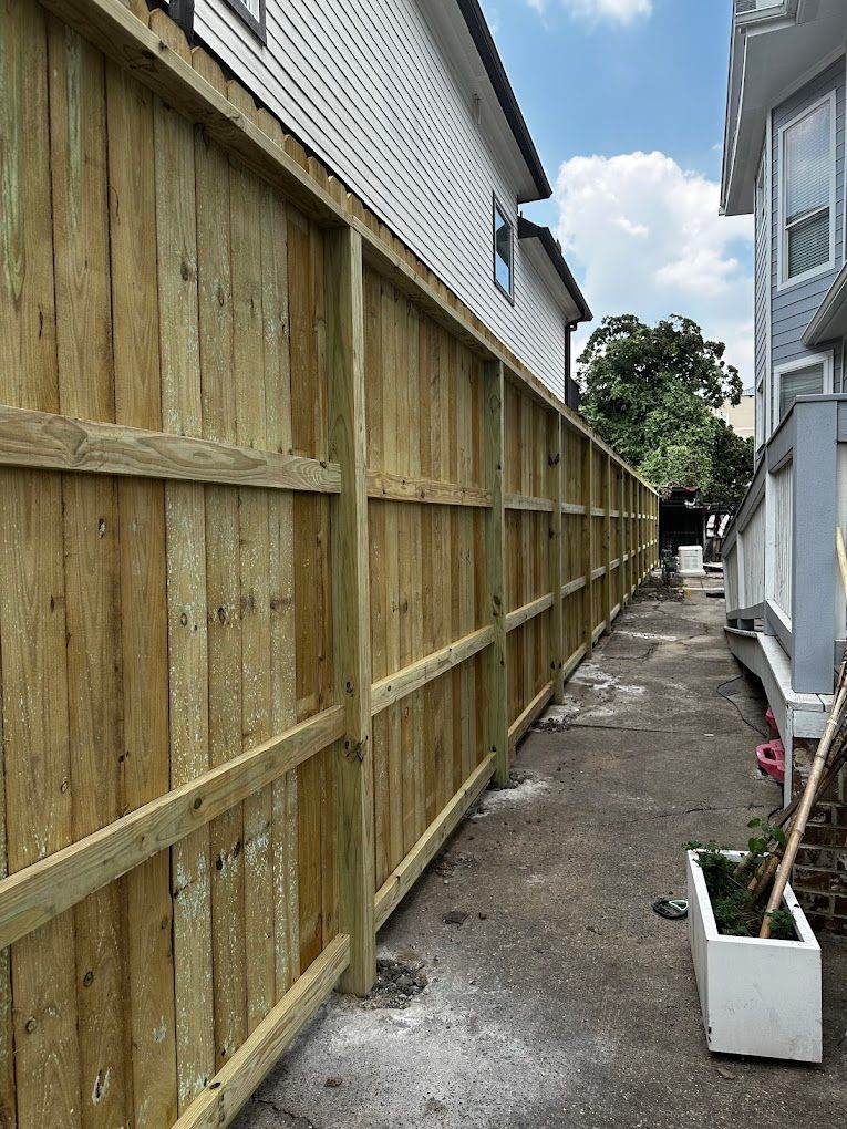 A wooden fence is being built between two houses.