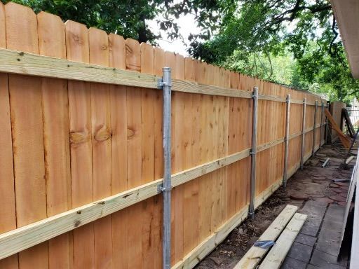 A wooden fence is being built next to a house.