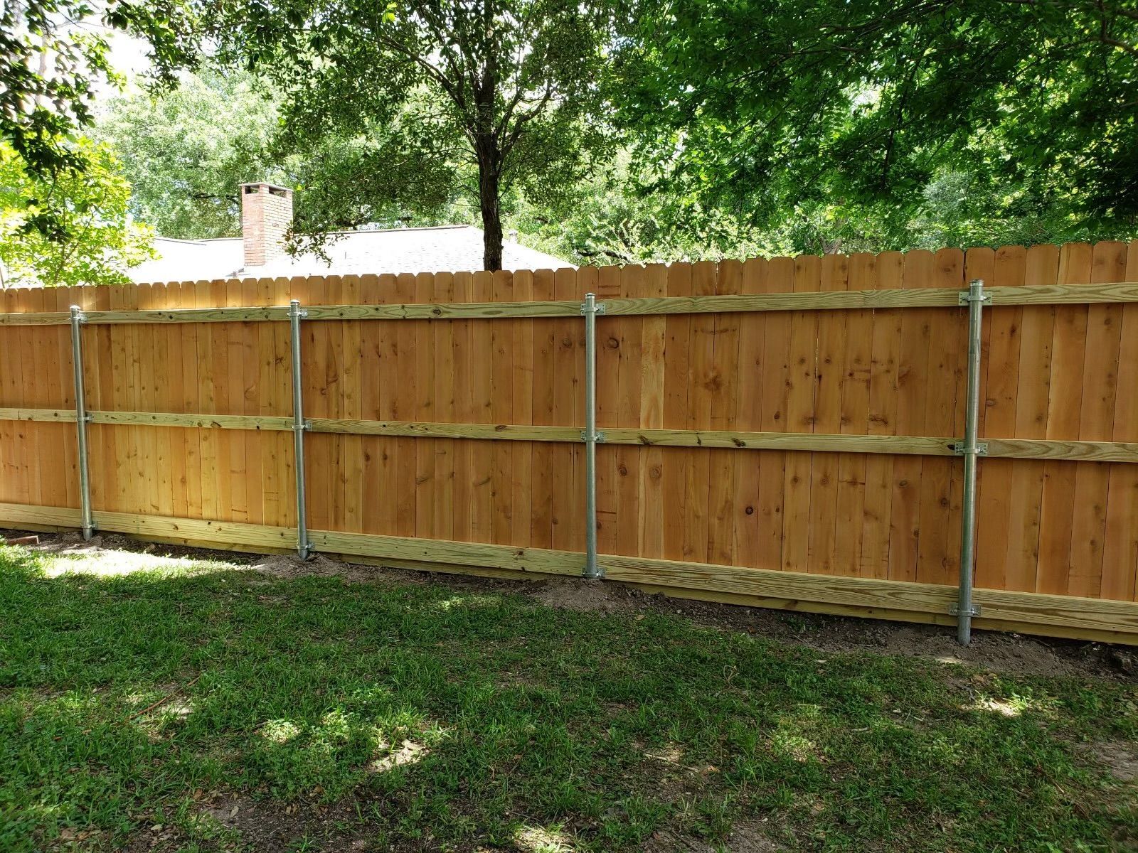 A wooden fence is sitting on top of a lush green lawn.