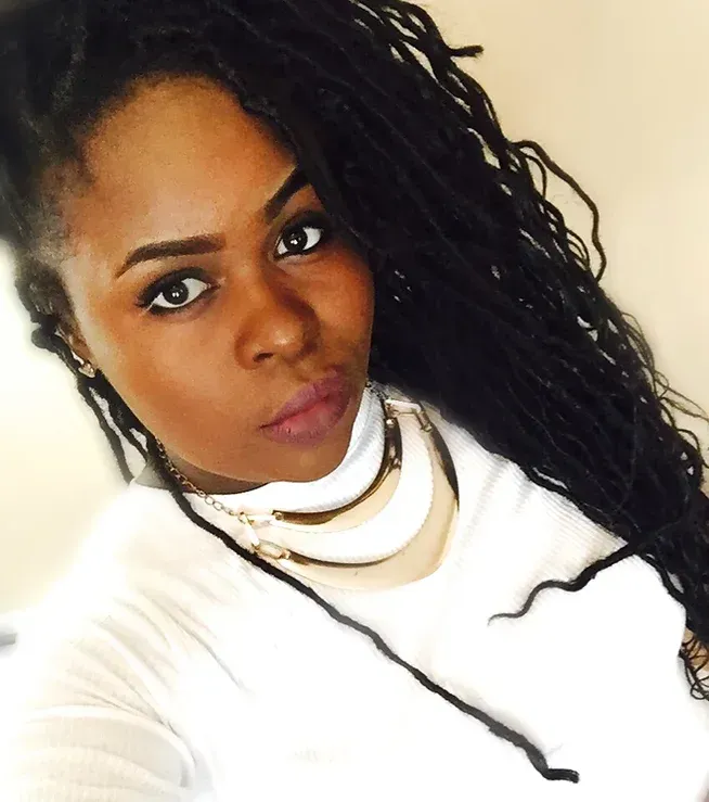 A woman with dreadlocks is wearing a white shirt