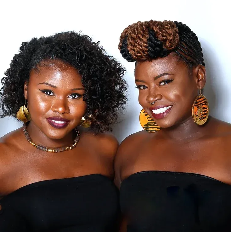 Two women are standing next to each other and smiling for the camera.