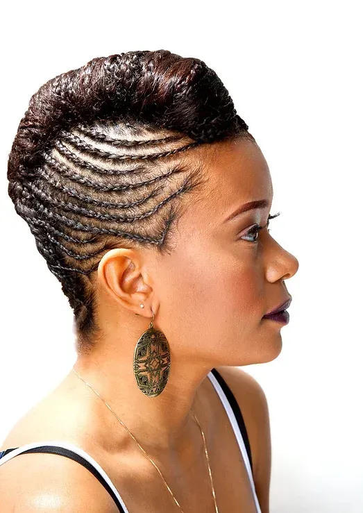 A woman with braided hair is wearing earrings