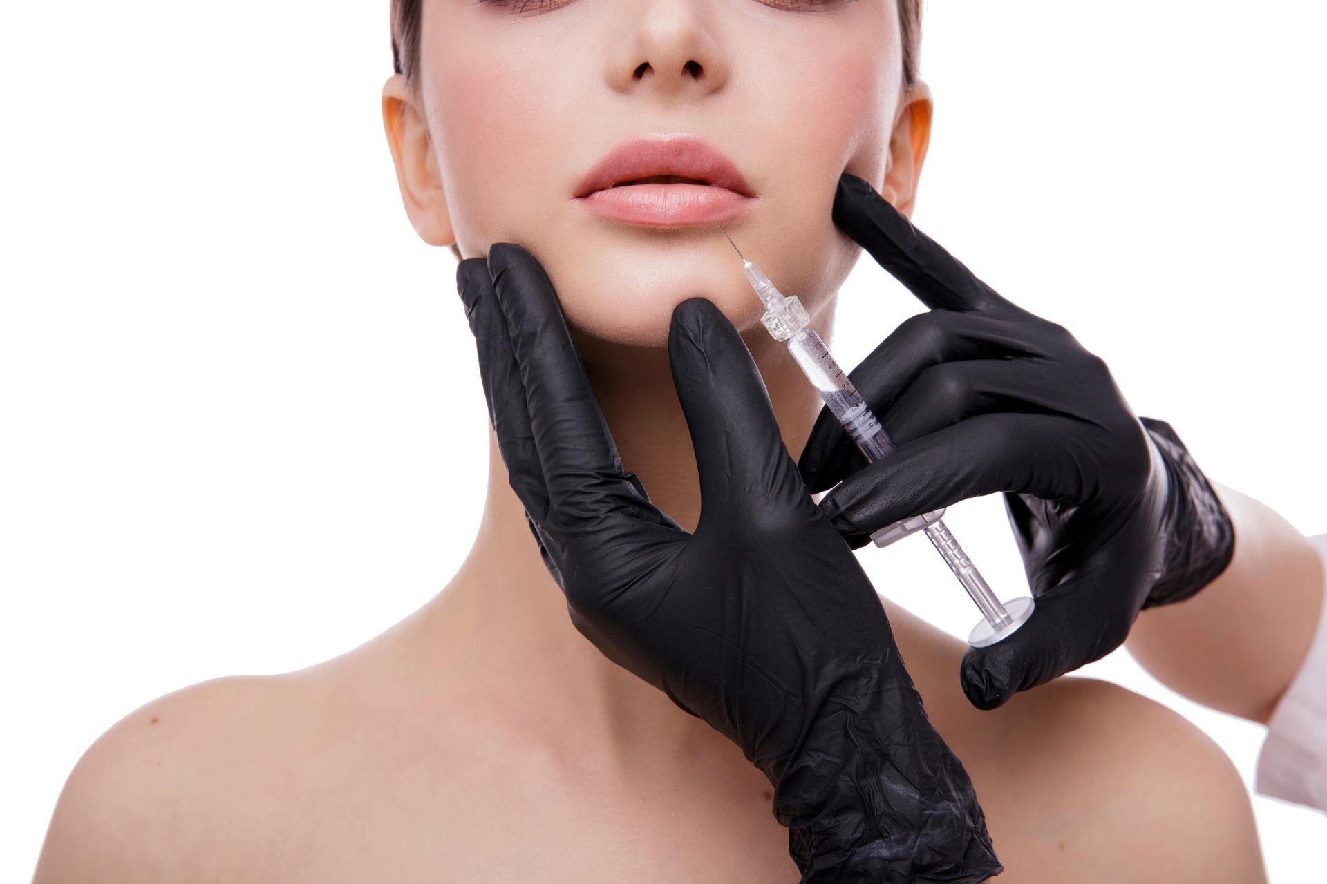 Gloved hands inject filler into a model’s chin during a cosmetic treatment