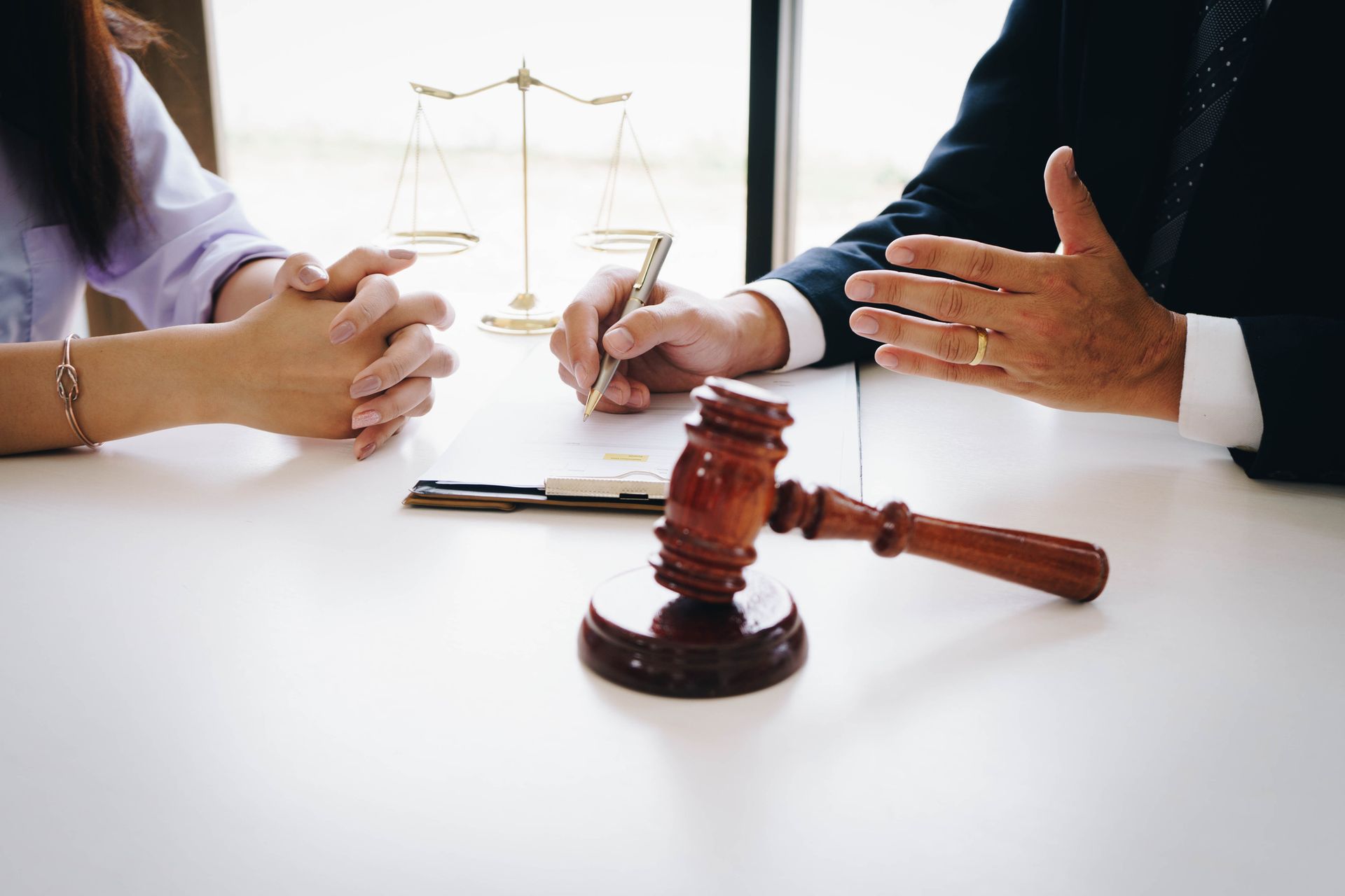 Lawyer consults client with justice scales and gavel – legal advice, courtroom, attorney office.