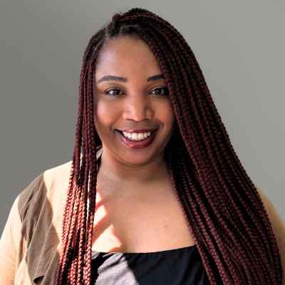 Smiling woman with long burgundy braids against a gray background