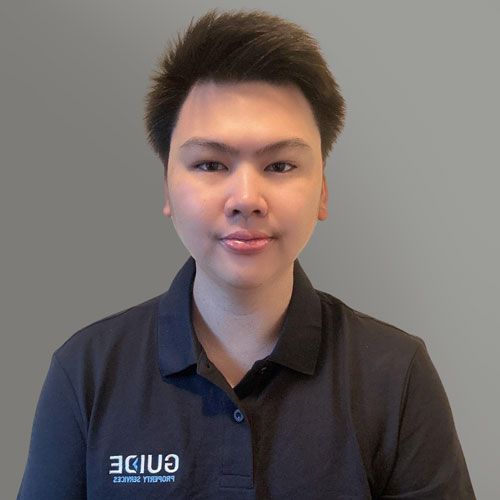 Person in a navy polo shirt facing the camera against a plain light background.