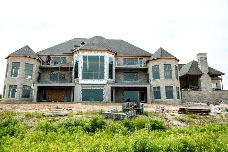 A large house with a lot of windows is under construction