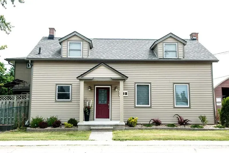 A house with a red door and a gray roof