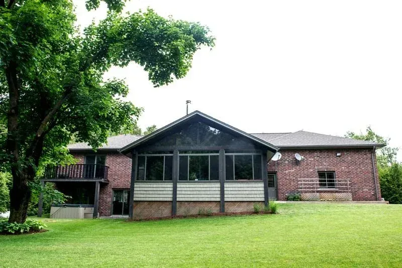 A large brick house with a screened in porch