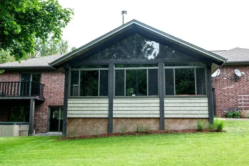 A large brick house with a screened in porch
