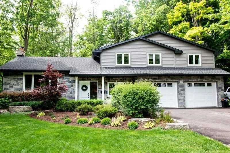 A large house with a lot of windows and a car parked in front of it.