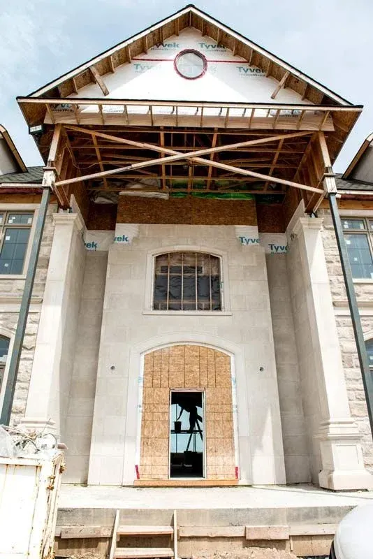 A large building under construction with a door that is boarded up
