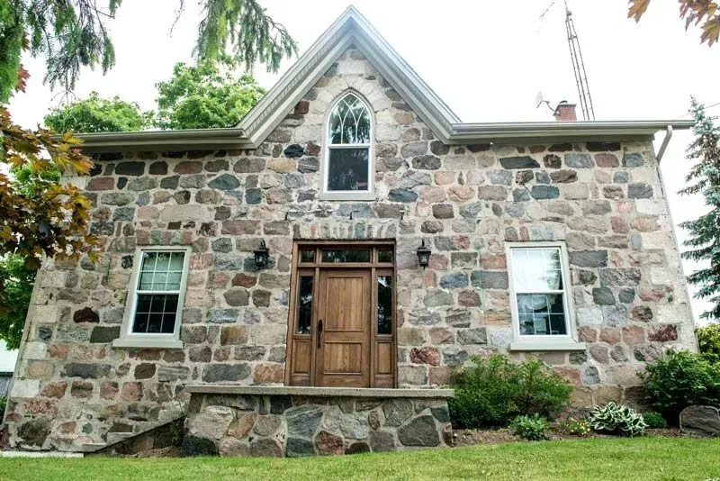 A large stone house with a wooden door and windows
