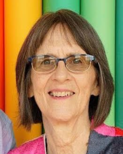 Woman with glasses smiling in front of colorful vertical panels